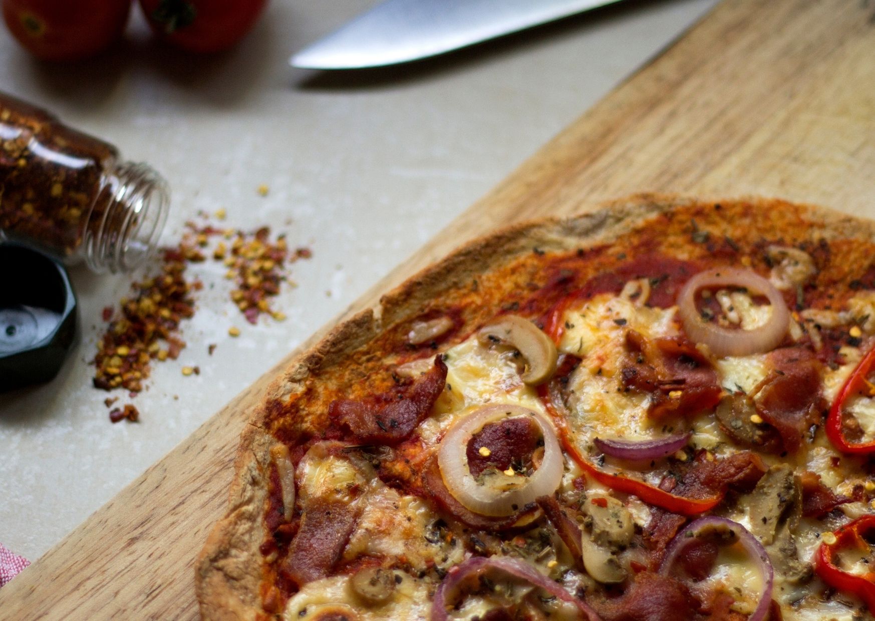 Pizza con masa integral, cubierta con puré de berenjenas, salsa adobada y un toque de papas