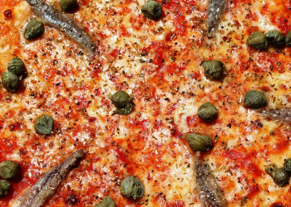 Pizza con queso Chubut, anchoas y alcaparras